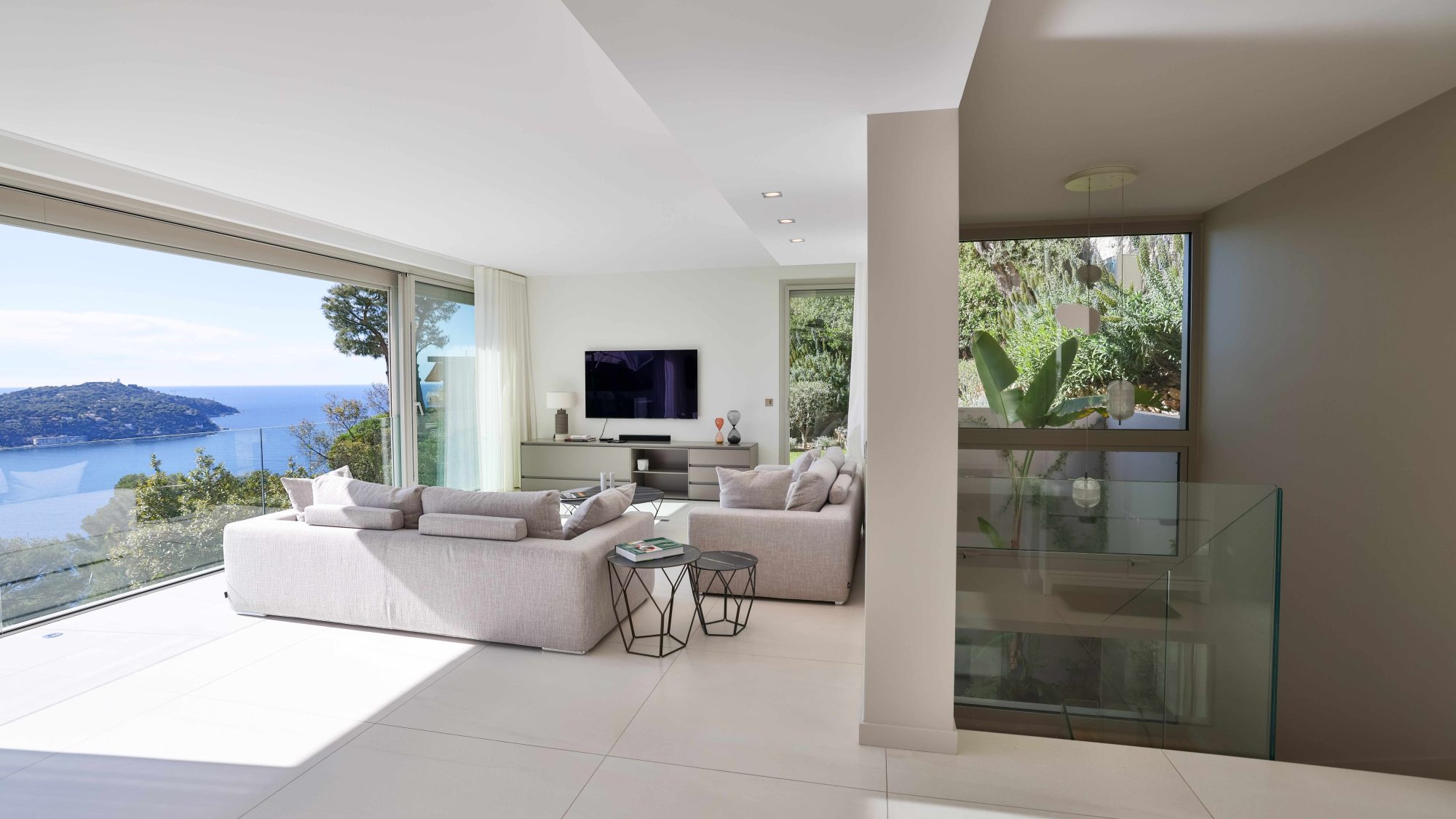 Luxury villa from Villa Magnifika. Interior of a bright, modern villa with large bay window overlooking the Mediterranean Sea.  